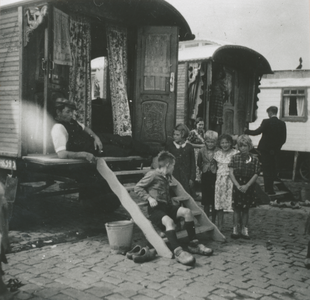 876865 Afbeelding van enkele woonwagens met een groepje kinderen, op het woonwagenkamp aan de Huppeldijk te Utrecht, ...